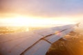 Airplane wing descending through the clouds at sunset Royalty Free Stock Photo