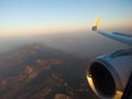 Airplane wing with engine out of window. Flight over land on sunrise. Airplane porthole view. Blurred image. Defocused Royalty Free Stock Photo