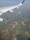 Airplane wing and fields aerial view from aeroplane window Royalty Free Stock Photo