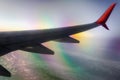 airplane wing in flight above clouds with optical effect Royalty Free Stock Photo