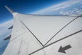 Airplane wing in flight over the horizon clouds