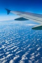 Airplane wing out of window, blue sky and clouds Royalty Free Stock Photo