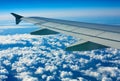 Airplane wing out of window, blue sky and clouds Royalty Free Stock Photo