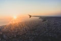 An airplane wing over a cityscape in Antalya, Turkey with the bright sun in the background Royalty Free Stock Photo