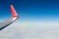 Airplane wing over clouds aerial top view from aircraft window, thick white blue clouds Royalty Free Stock Photo