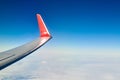 Airplane wing over clouds aerial top view from aircraft window, thick white blue clouds Royalty Free Stock Photo