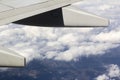 Airplane wing from plane above the clouds