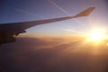 Airplane wing at sunset sky.