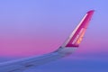 Airplane wing in the sky. Wizz Air logo against the background of evening violet purple sky