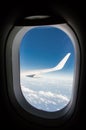 Airplane wing though the window during flight Royalty Free Stock Photo