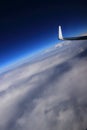 Airplane wing tip above clouds blue sky Royalty Free Stock Photo