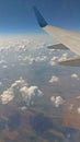 Airplane wing view out of the window on the cloudy sky background. Holiday vacation background. Wing of airplane flying above the Royalty Free Stock Photo