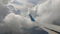 Airplane wing view out of the window on the cloudy sky background. Holiday vacation background. Wing of airplane flying above the Royalty Free Stock Photo