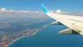 Airplane wing view out of the window on the cloudy sky The Earth and the blue sea. background. Holiday vacation background. Wing Royalty Free Stock Photo