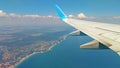 Airplane wing view out of the window on the cloudy sky The Earth and the blue sea. background. Holiday vacation background. Wing Royalty Free Stock Photo