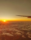 Airplane wing view through airplane window at sunset. Royalty Free Stock Photo