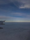 Airplane wing viewed from a passenger window, showing a section of the wing extending into the scene Royalty Free Stock Photo