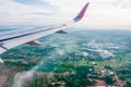 Airplane wings during the flight, viewed from the passenger window There are many white clouds in the blue sky above the ground,