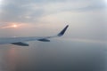 Airplane wings during sunset in a clear pinky sky. Royalty Free Stock Photo