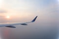 Airplane wings during sunset in a clear pinky sky. Royalty Free Stock Photo