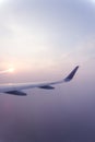 Airplane wings during sunset in a clear pinky sky. Royalty Free Stock Photo