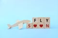 Airplane wooden model on blue background. Travel and flying soon after covid-19 pandemic and dream destination concept.