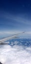 Airplane window seat view showing beautiful cloudy blue sky Royalty Free Stock Photo