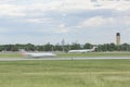 Airplanes descends from sky onto runway.