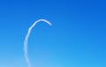 Airplanes leave curved trace on clear blue sky. View from below Royalty Free Stock Photo