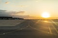 Airport, airplanes and service vehicles on aerodrome at sunset