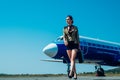 Airport and charming stewardess on blue airplane background. Portrait of charming stewardess wearing in blue uniform Royalty Free Stock Photo