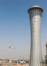 Airport control tower with a background of a plane taking off