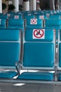 Airport during the coronavirus pandemic. Social distancing. Empty blue chairs with a Restricted No-Sitting Sign. Prevention of inf Royalty Free Stock Photo