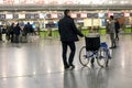 An airport employee driving a wheelchair at the airport. Selected focus