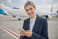 Airport employee holding a gadget in her hands Royalty Free Stock Photo