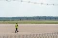 Airport employees are on the runway. The territory of the private airfield is fenced with barbed wire and a fence. The traffic