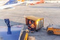 airport employees unload suitcases, passengers luggage from conveyor Royalty Free Stock Photo