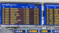 Airport flight information displayed on departure board, flight status changing. Flight schedule screen at airport showing