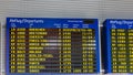 Airport flight information displayed on departure board, flight status changing. Flight schedule screen at airport showing