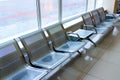 Airport gate waiting area with metal seats Royalty Free Stock Photo