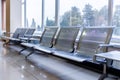 Airport gate waiting area with metal seats Royalty Free Stock Photo