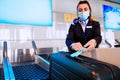 Airport ground staff sits at the counter, weighing luggage and registration Royalty Free Stock Photo
