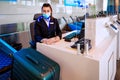 Airport ground stafft sits at the counter, weighing luggage and registration Royalty Free Stock Photo