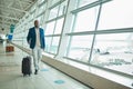 Airport luggage, travel and black man walking to airplane, flight booking or transportation for corporate trip. Suitcase Royalty Free Stock Photo