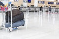 Airport luggage Trolley with suitcases, unidentified man woman walking in the airport, station, France Royalty Free Stock Photo