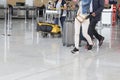 Airport luggage Trolley with suitcases, unidentified man woman walking in the airport, station, France Royalty Free Stock Photo