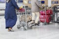 Airport luggage Trolley with suitcases, unidentified man woman walking in the airport, station, France Royalty Free Stock Photo