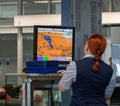 Airport, munich, germany, 2019 april 09: women in uniform standing at counter at checking point and watching at monitor with x-ray Royalty Free Stock Photo