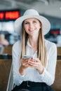 Airport phone travel woman using mobile phone in business class lounge waiting for plane flight texting sms message on Royalty Free Stock Photo