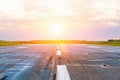 Airport runway airplanes with traces of rubber tires at dawn in the morning with sun glare. Royalty Free Stock Photo